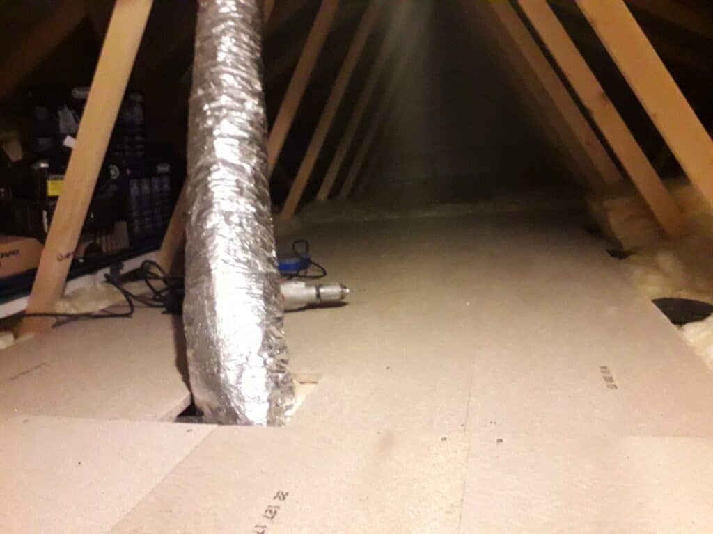 A boarded out loft space with a whole cut for foil ventilation pipework ducting