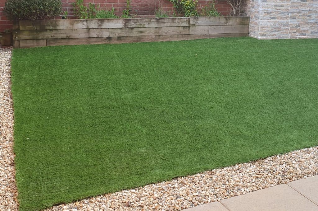 Artificial fake grass with some dirt on it which could be vacuumed up
