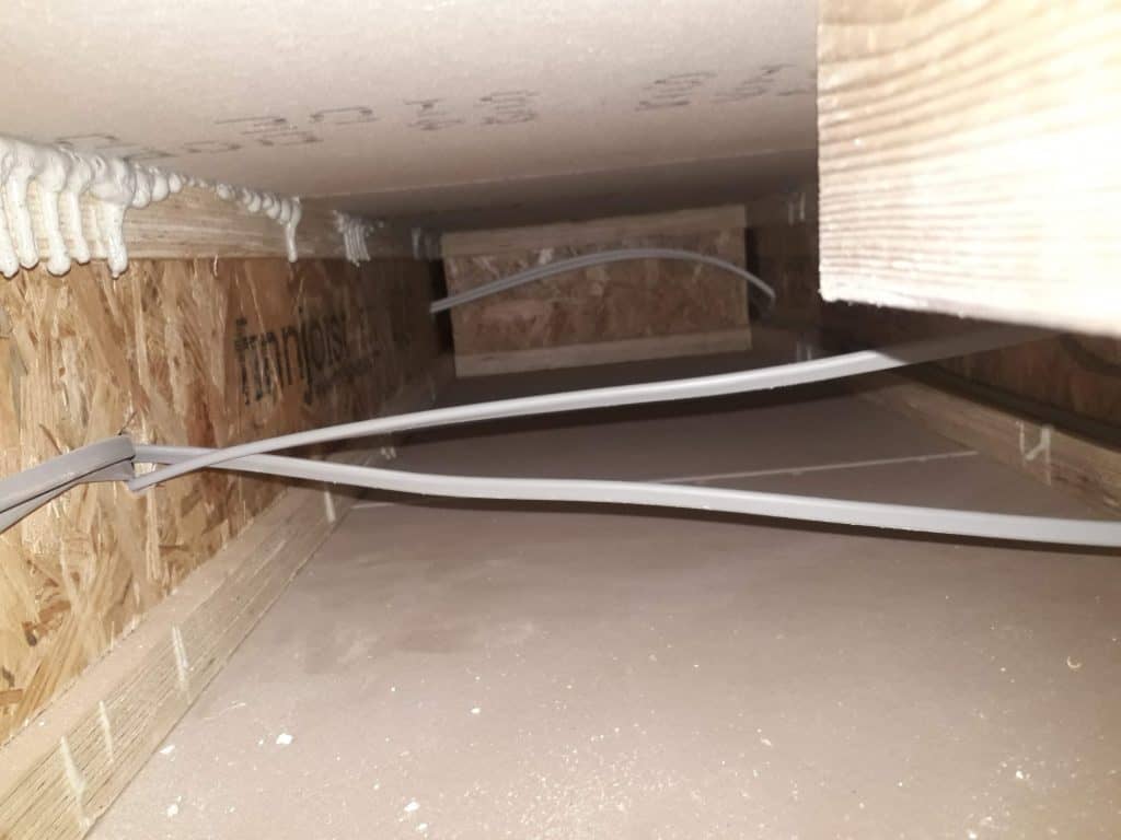 Wire and UPVC pipes under a floodboard