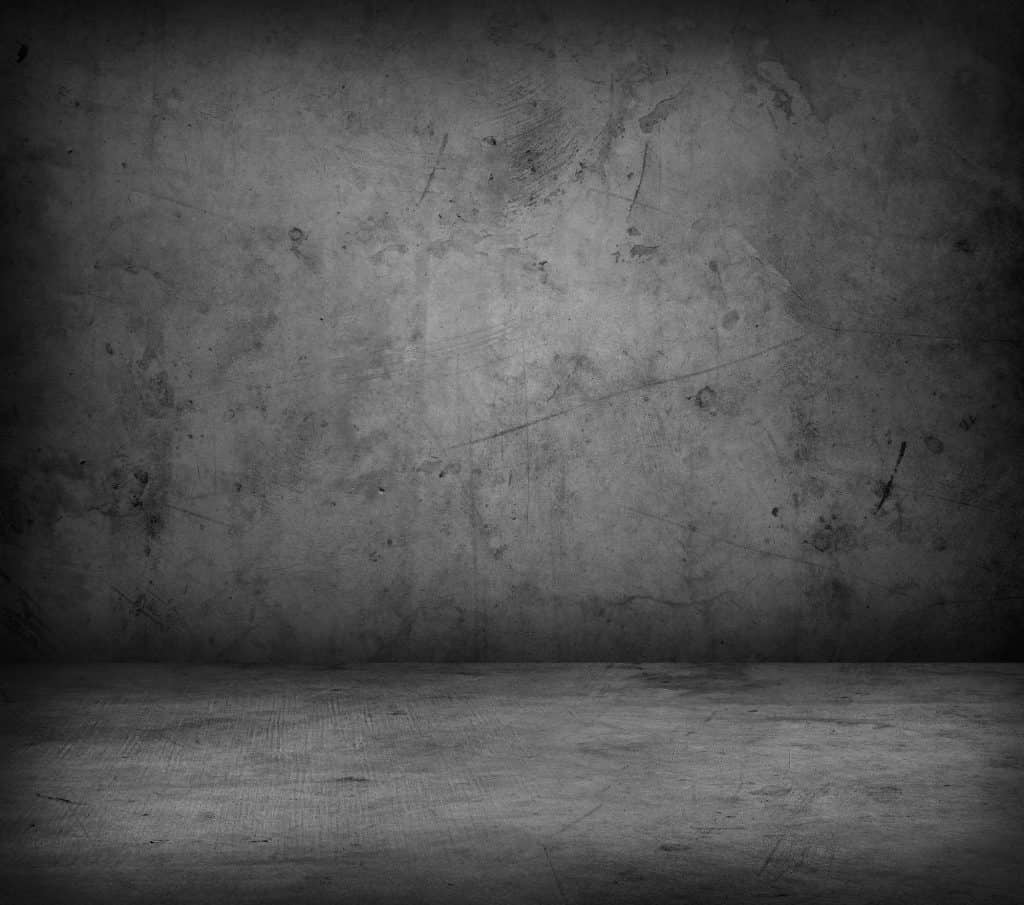 A darkened concrete floor and wall
